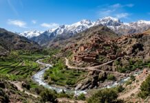 Best Day Trips from Marrakech: High Atlas Mountains, Essaouira, Agafay Desert & Ouzoud Falls High Atlas Mountains landscape with Berber village, terraced fields, and snow-capped peaks