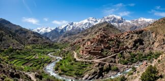Best Day Trips from Marrakech: High Atlas Mountains, Essaouira, Agafay Desert & Ouzoud Falls High Atlas Mountains landscape with Berber village, terraced fields, and snow-capped peaks