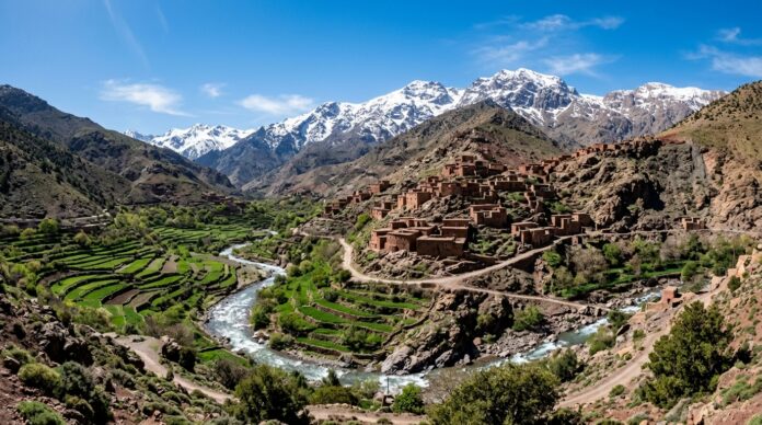 High Atlas Mountains landscape with Berber village, terraced fields, and snow-capped peaks