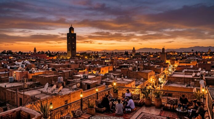 Sunset panoramic view over Marrakech rooftops with illuminated Koutoubia Mosque