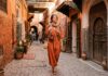 What Should Women Wear in Marrakech? Dress Code, Modesty & Safety Guide Woman traveler in modest stylish linen dress and scarf in Marrakech medina