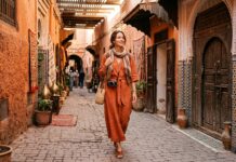 What Should Women Wear in Marrakech? Dress Code, Modesty & Safety Guide Woman traveler in modest stylish linen dress and scarf in Marrakech medina