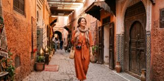 What Should Women Wear in Marrakech? Dress Code, Modesty & Safety Guide Woman traveler in modest stylish linen dress and scarf in Marrakech medina