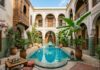 Where to Stay in Marrakech: Riads vs Hotels and Neighborhood Guide Traditional luxury Moroccan riad courtyard with turquoise pool and zellige tilework