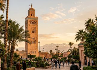 Marrakech Travel Guide: Complete First-Timer’s Planning Guide Koutoubia Mosque minaret in Marrakech Morocco framed by palm trees and Atlas mountains at sunset