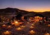 Morocco Sahara Desert Guide: Erg Chebbi vs Erg Chigaga, Camps & Logistics Traditional Berber luxury desert camp with lanterns in Erg Chebbi sand dunes at dusk