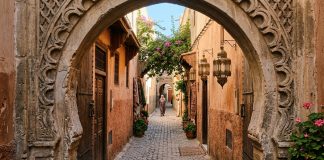 Morocco Travel Tips for First-Time Visitors: 25 Essential Things to Know Quiet sunlit cobblestone alleyway through stone keyhole archway in Moroccan medina