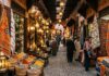 How to Navigate Marrakech Souks Without Getting Lost: Shopping & Haggling Guide Marrakech souk alleyway adorned with illuminated brass lanterns and Berber rugs