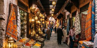 How to Navigate Marrakech Souks Without Getting Lost: Shopping & Haggling Guide Marrakech souk alleyway adorned with illuminated brass lanterns and Berber rugs