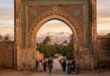 How to Travel to Morocco: The Complete Step-by-Step Guide for First-Timers (2026) Travel to Morocco: Gateway arch framing palm trees and snow-capped Atlas Mountains