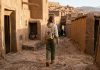 What to Wear in Morocco: A Respectful & Practical Dress Code Guide Traveler in loose linen pants and cotton shirt walking through Ait Ben Haddou Morocco