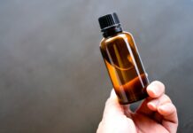 Argan Oil Guide: 12 Uses for Hair and Skin, Real Benefits and How to Buy It Pure Argan oil in an amber glass dropper bottle held in hand