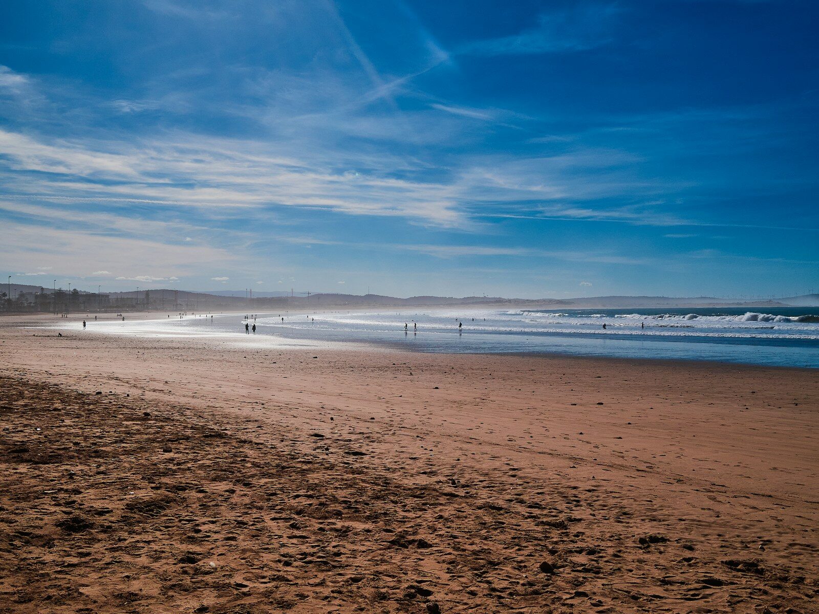 Essaouira beach with people walking along the Atlantic shore