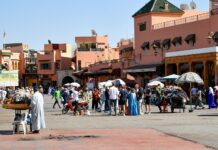 Morocco Travel Safety: 15 Worst Mistakes Tourists Make Busy market square with vendors in Marrakech, where Morocco safety tips on scams and agreeing prices matter most