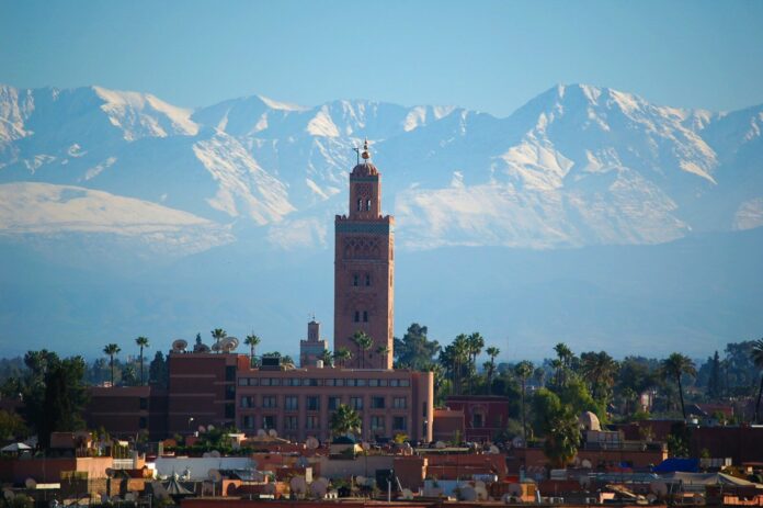 Moroccan Marrakech Koutoubia minaret Moroccan Marrakech skyline with the Koutoubia minaret and the snow-capped Atlas Mountains