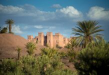 Morocco Travel Guide: Where It Is, What to Do and How Many Days You Need Morocco vacation route past an earthen kasbah and palm trees in the south