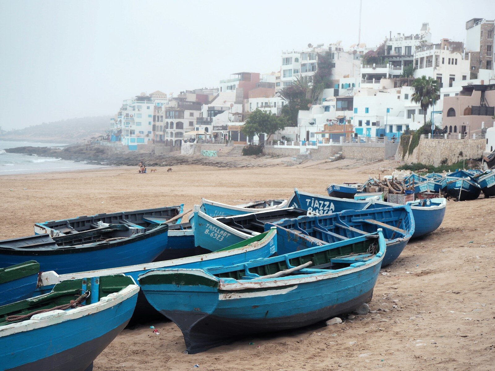 Taghazout beach with blue fishing boats resting on the sand