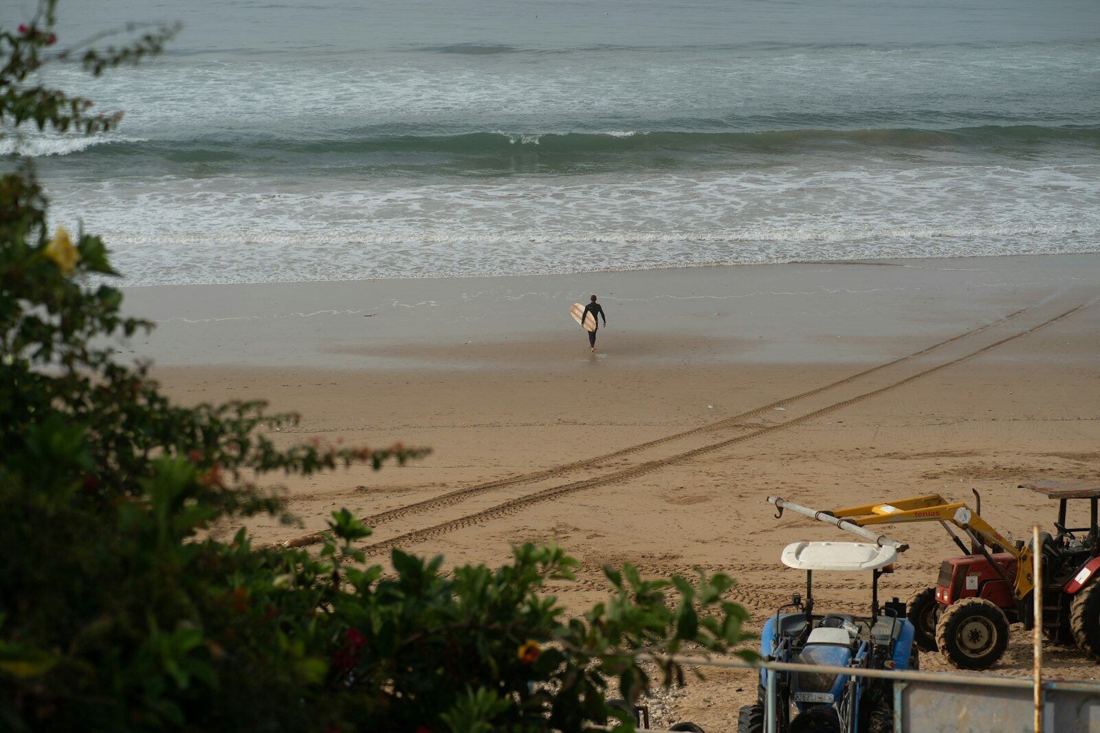 Taghazout surf camp guest walking along the beach with a surfboard