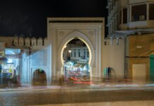 Tangier Tourist Attractions: 15 Best Places to Visit, Costs and Tips Tangier tourist attractions: a white arched medina gate lit up at night