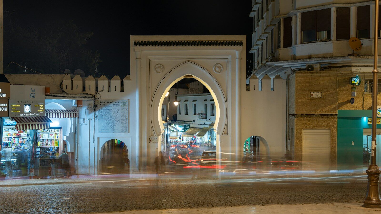 Tangier tourist attractions: a white arched medina gate lit up at night