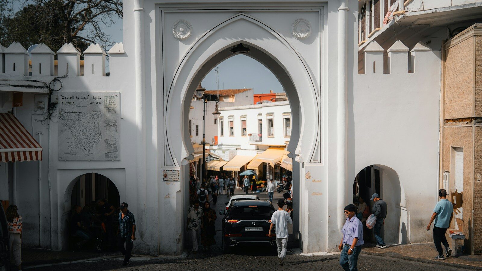 People walking through an ornate arched gate, one of the first things to do in Tangier